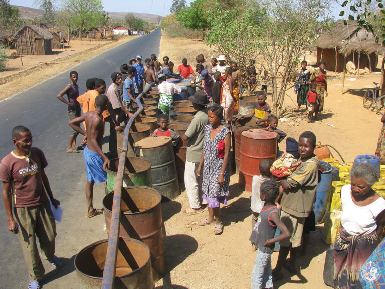 Filling barrels with water brought by a lorry of the Mission